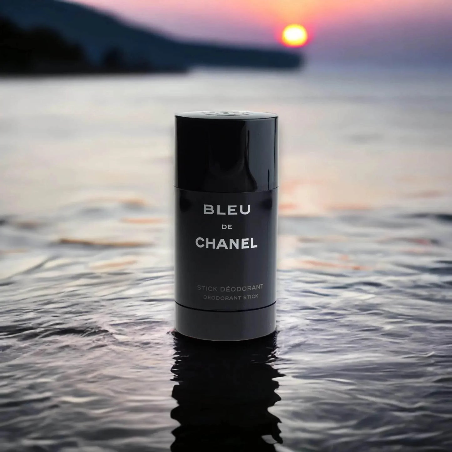 Bleu de Chanel Deodorant Stick steht auf WasseroberflÀche bei Sonnenuntergang, Luxusduft Produktfoto