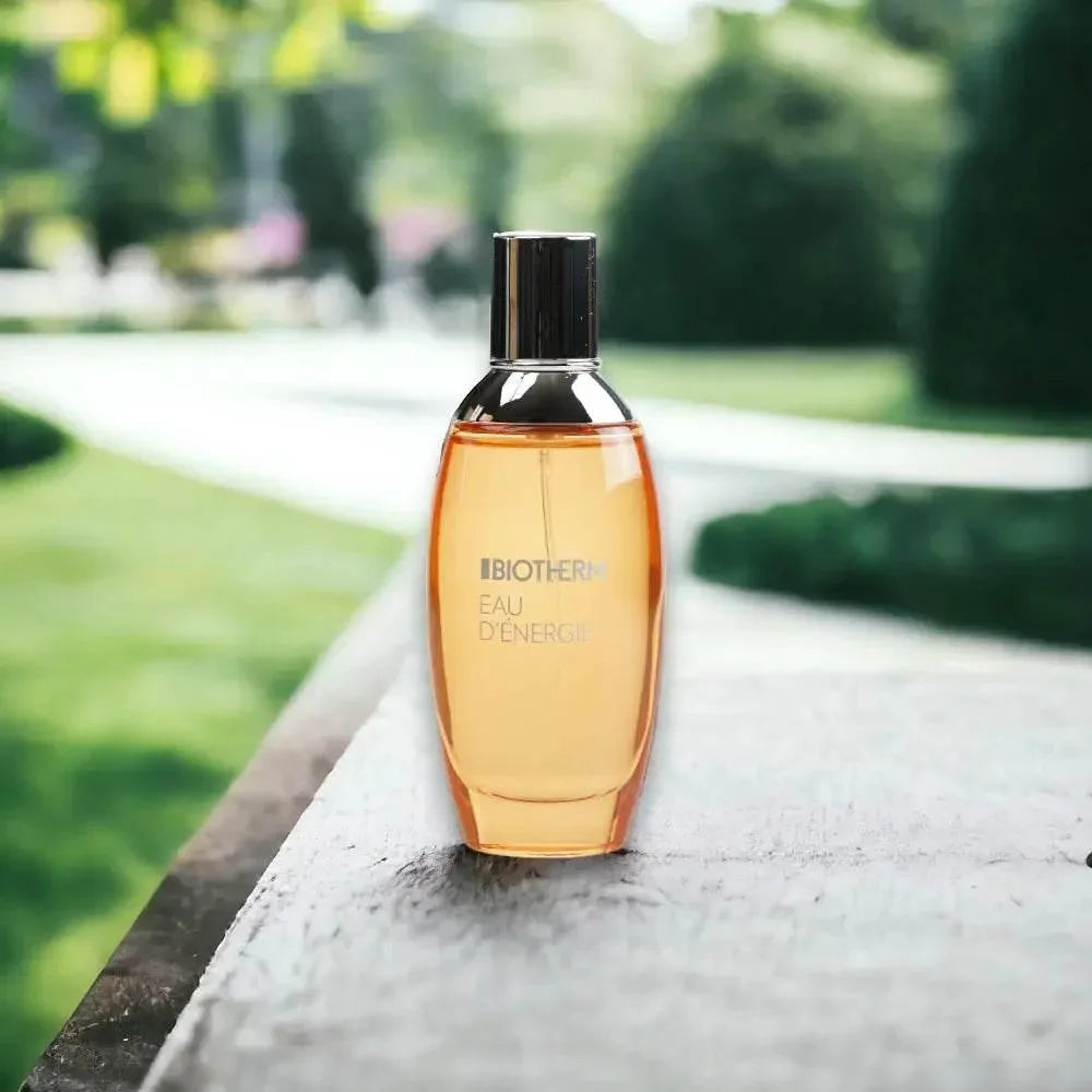 Eau de Toilette Flakon Eau d'Énergie auf Holztisch im Garten, elegantes Parfum für Damen