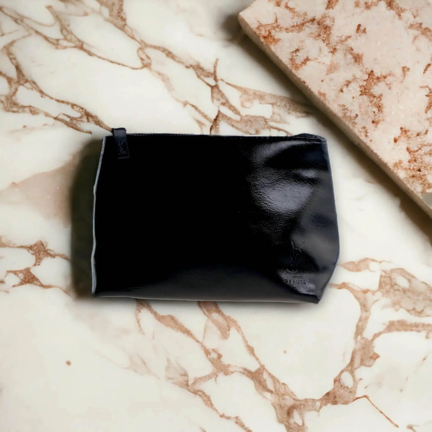 Schwarze Kosmetiktasche aus Leder auf Marmor-OberflÀche, elegantes Accessoire