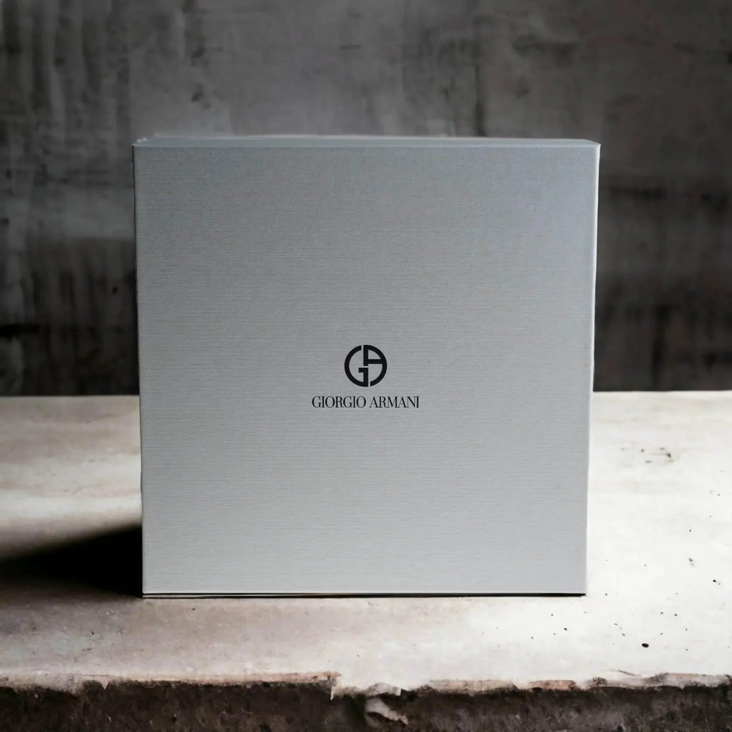 Elegante graue ParfĂŒm-Geschenkbox mit Giorgio Armani Logo auf Steinuntergrund