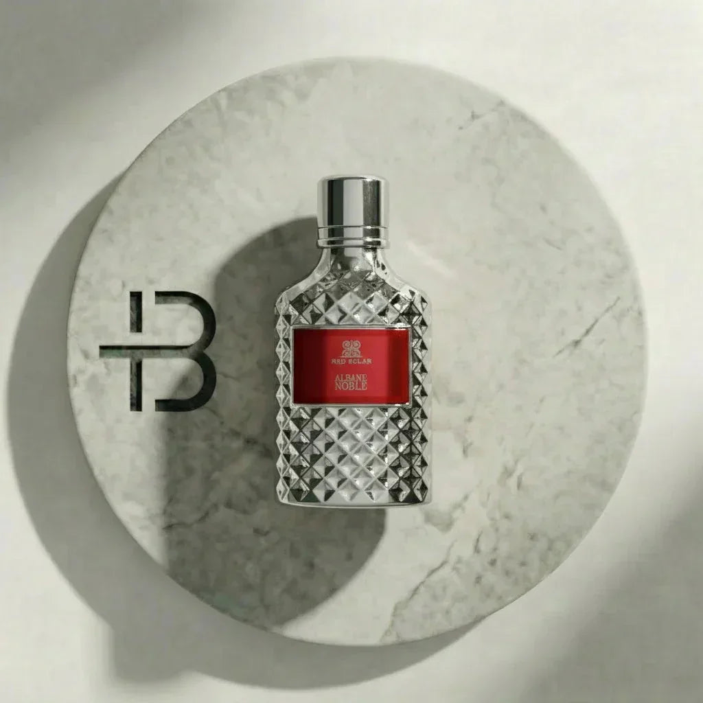 Luxusparfumflakon mit diamantartigem Muster und rotem Etikett auf Marmoruntergrund
