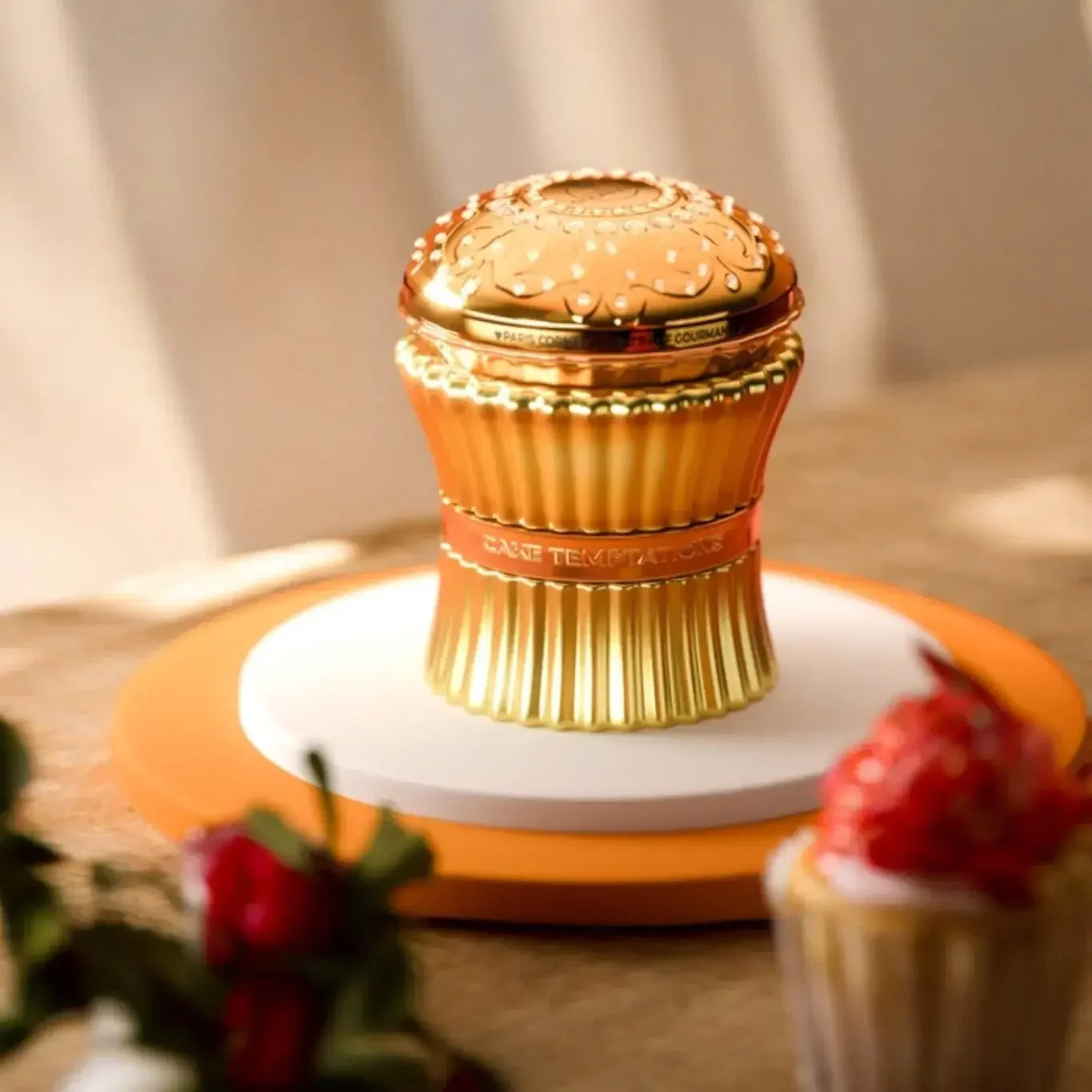 Luxusparfüm in goldener Cupcake-Flakon auf Tisch, elegant und verspielt, Dessertdeko