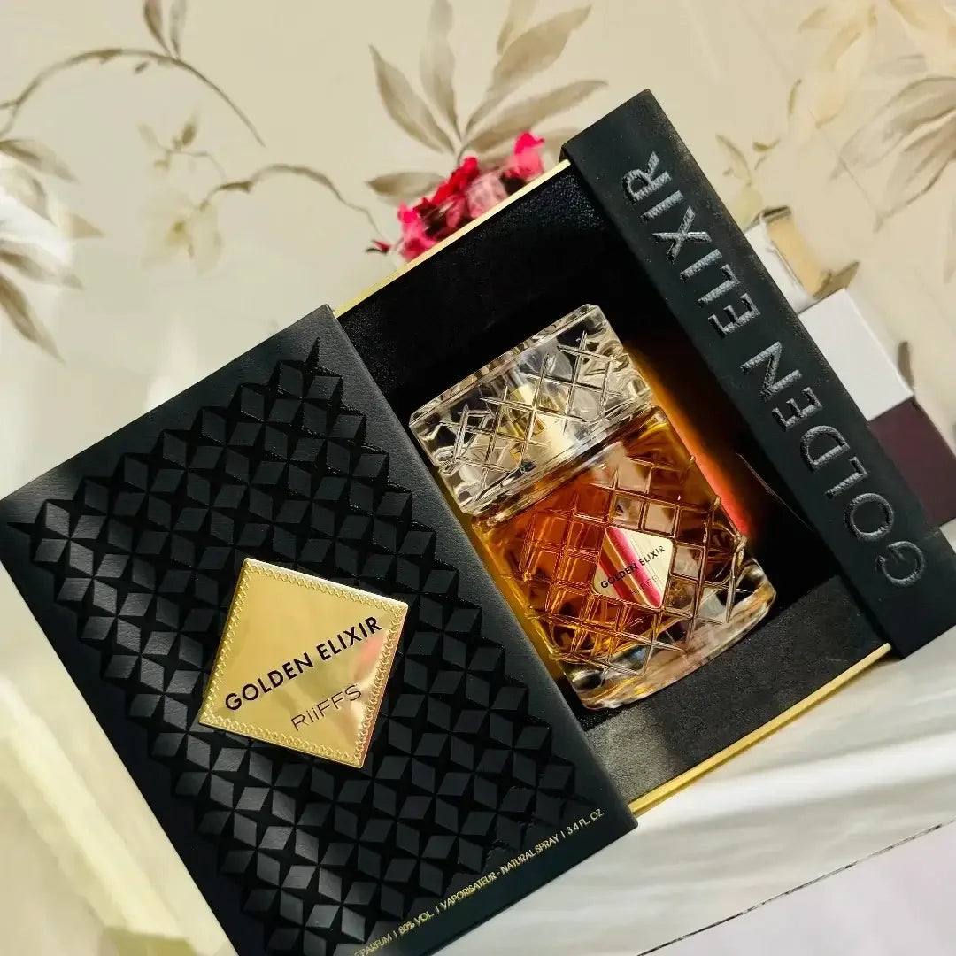 Luxusparfum Golden Elixir in eleganter Kristallflasche mit edler Geschenkbox, dekorativ platziert