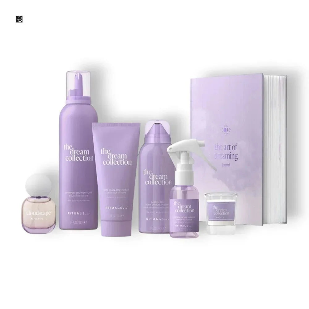Lila Parfum- und Körperpflege-Set mit Duschschaum, Body Cream, Spray, Duftkerze und Buch auf weißem Hintergrund.