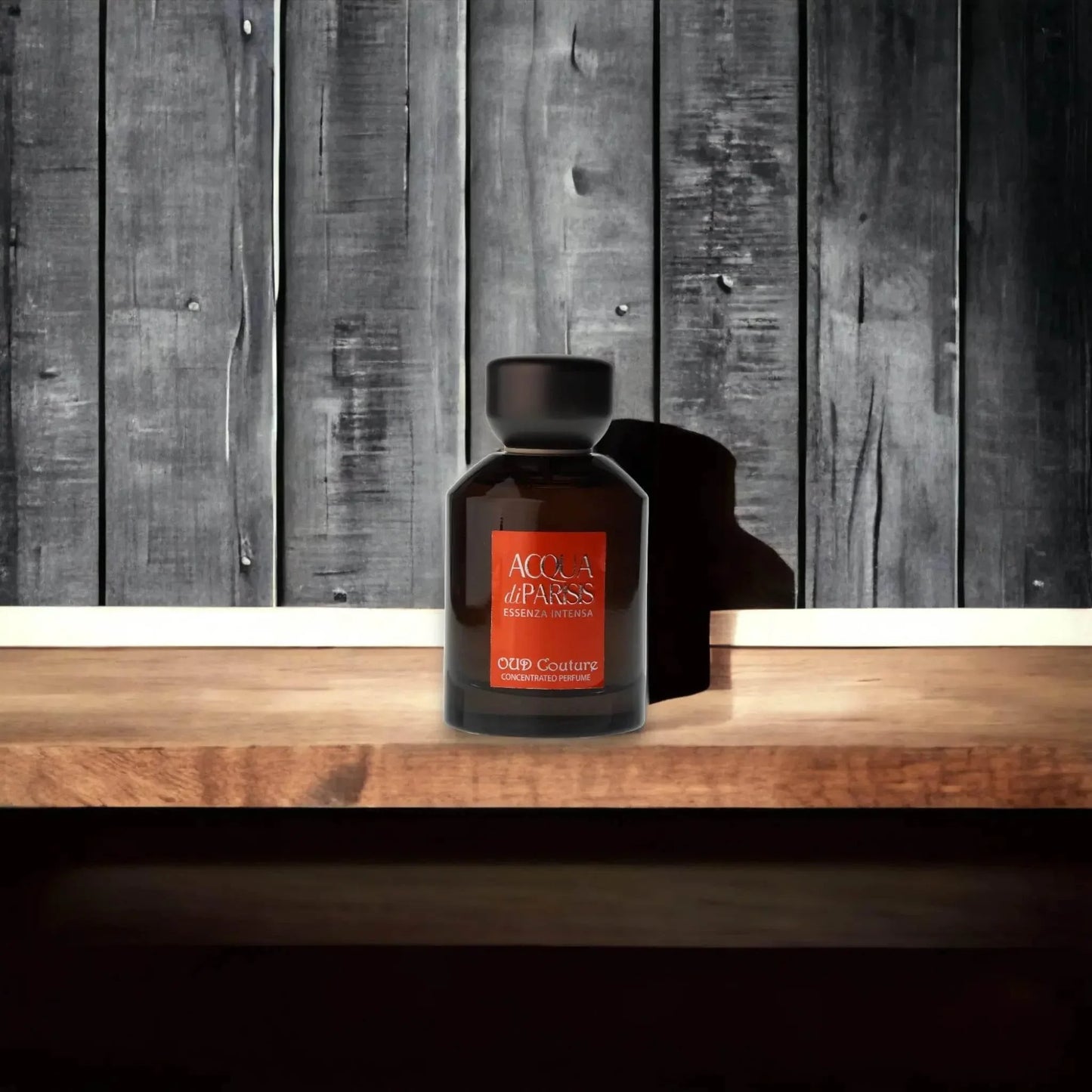 Edles Parfumflakon Acqua di Parisis Essenza Intensa Oud Couture auf Holztisch vor Holzstruktur