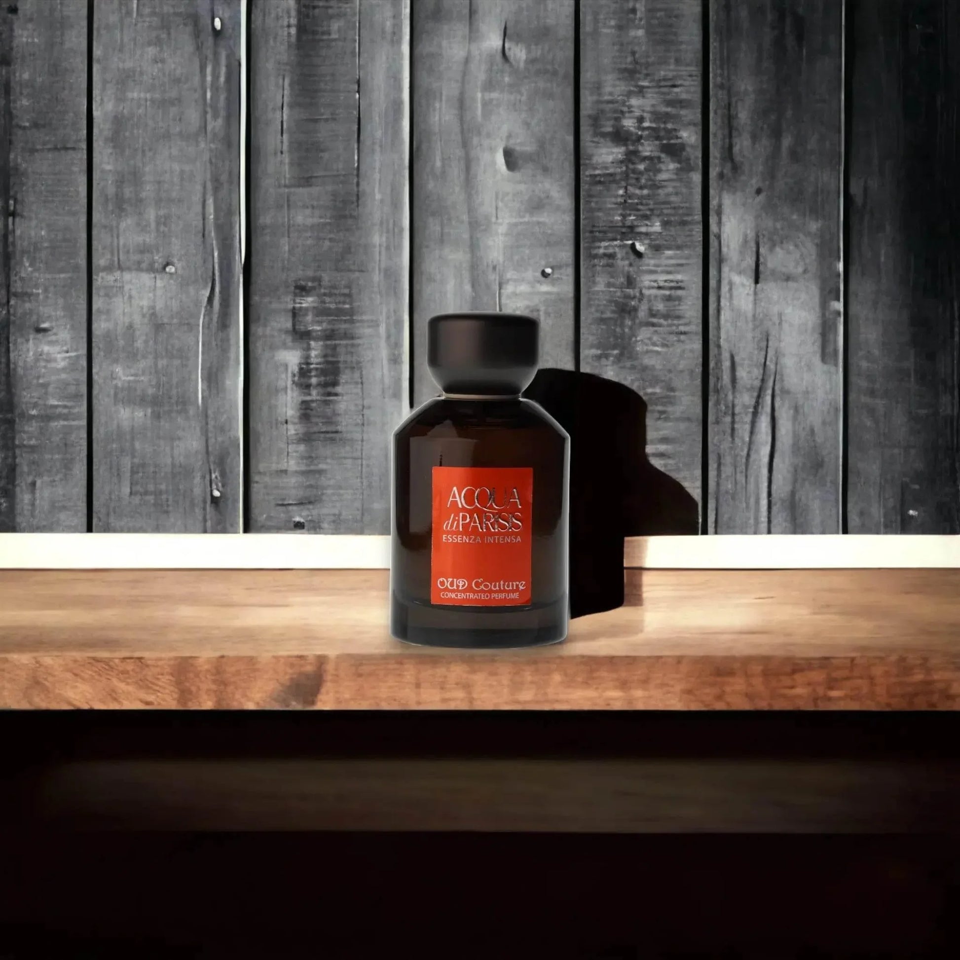 Edles Parfumflakon Acqua di Parisis Essenza Intensa Oud Couture auf Holztisch vor Holzstruktur
