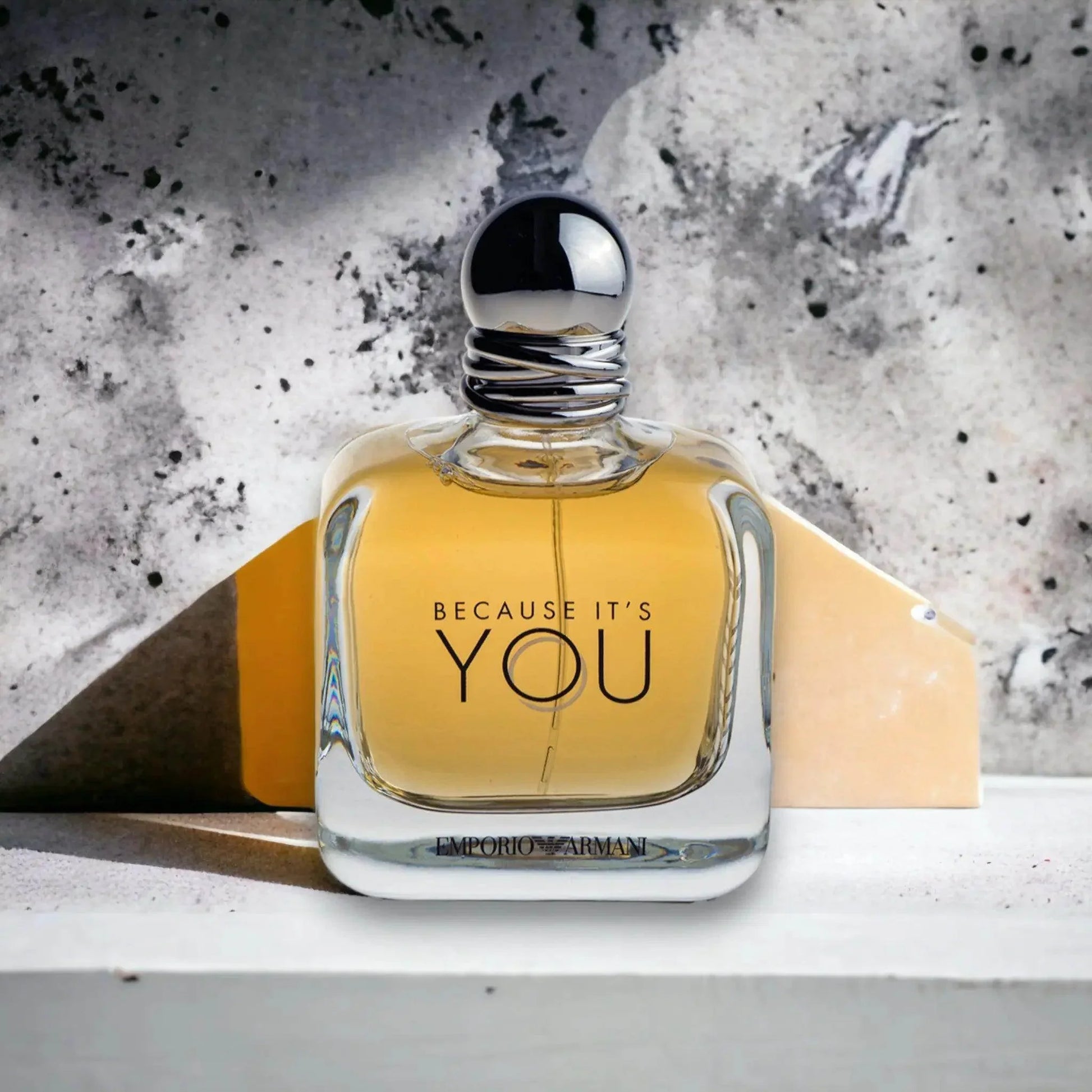 Luxus Eau de Parfum Flakon, goldene Flüssigkeit, stilvoll vor Betonhintergrund, Unisex Duft