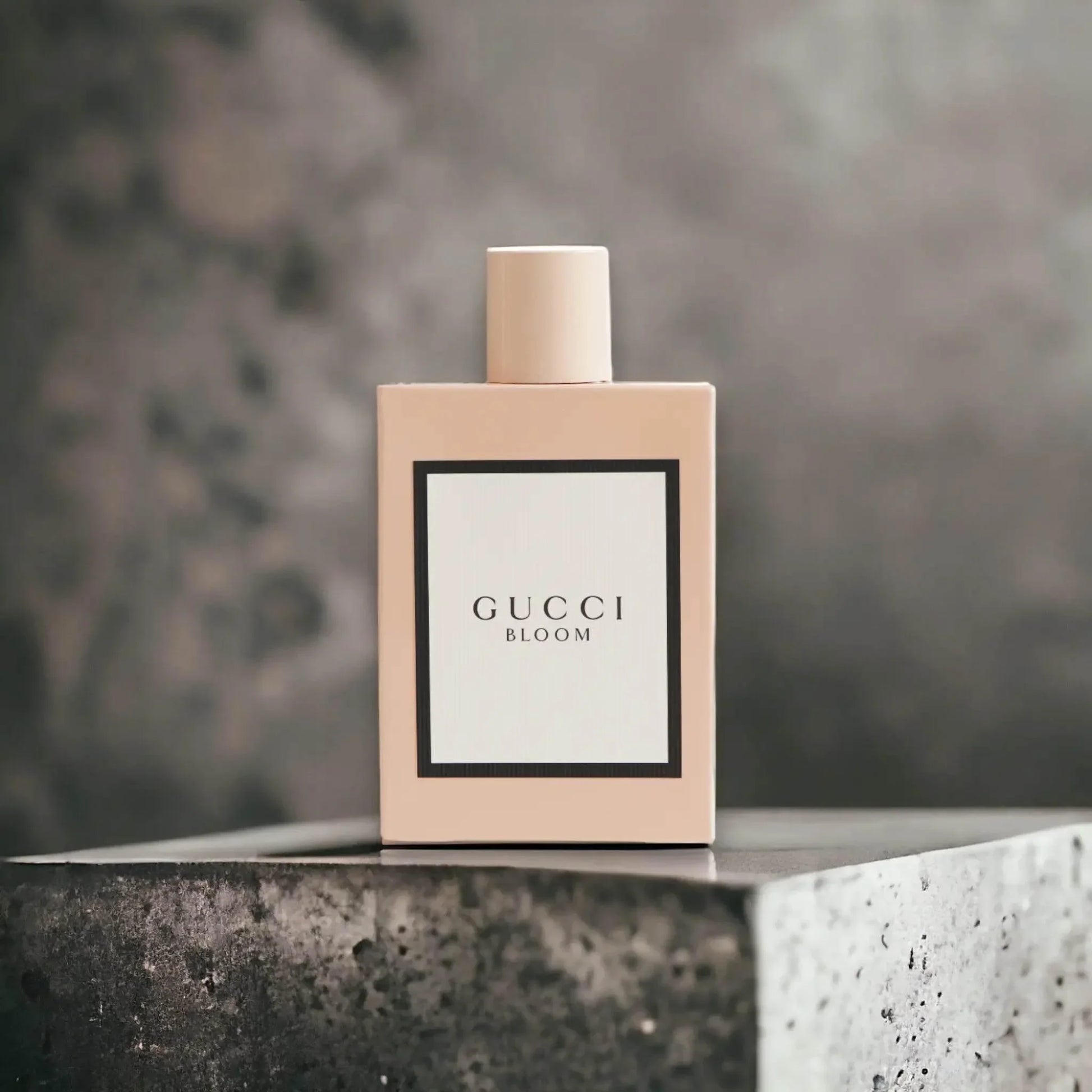 Gucci Bloom Eau de Parfum in rosa Flakon vor grauem Hintergrund, Luxus Damenparfum
