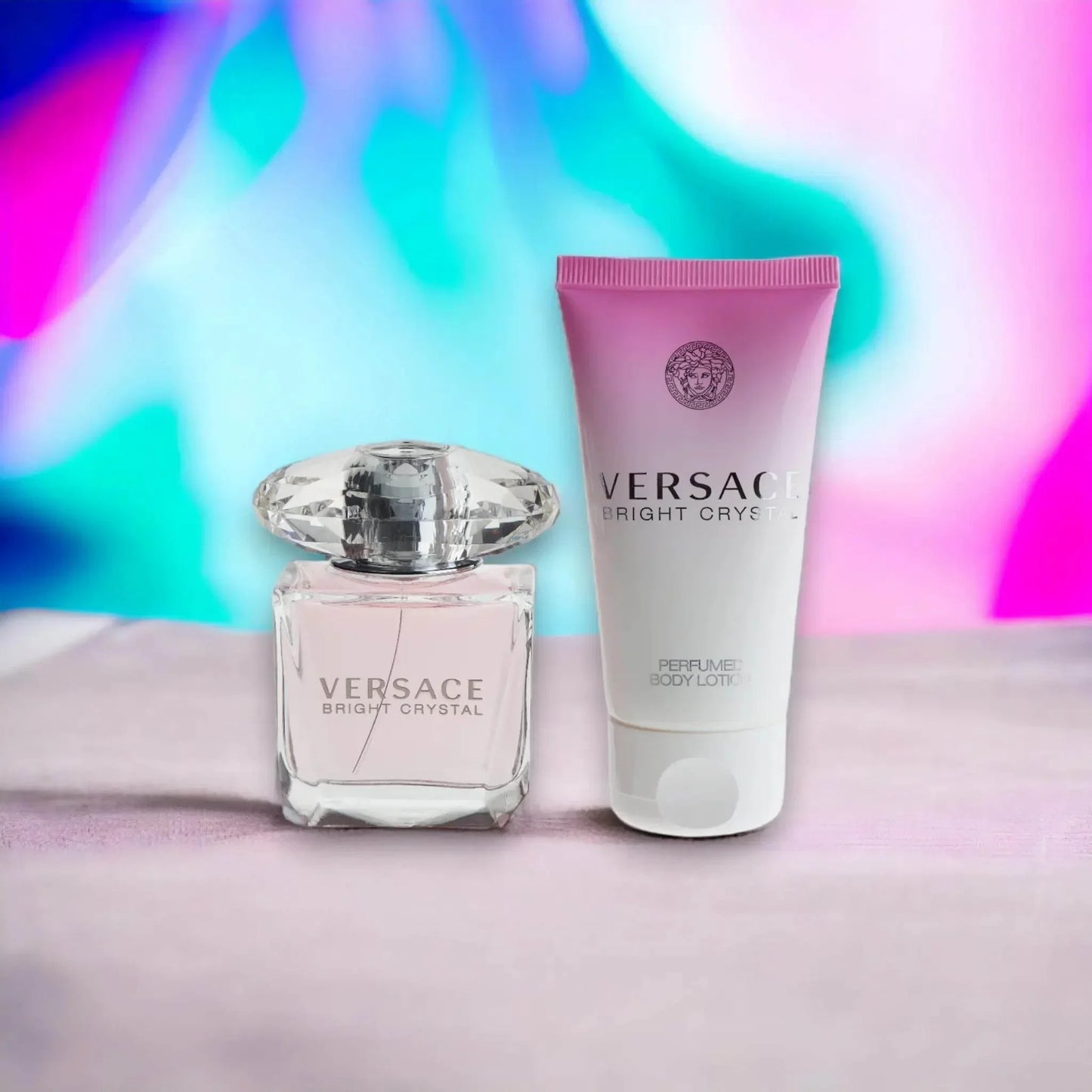 Versace Bright Crystal Parfum und Bodylotion Set auf pastellfarbenem Hintergrund.
