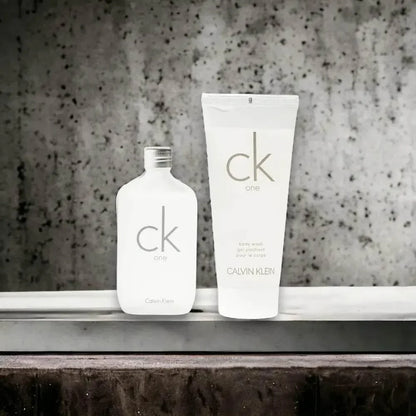 CK One Duftset mit Eau de Toilette und Duschgel, minimalistisch, vor Betonwand
