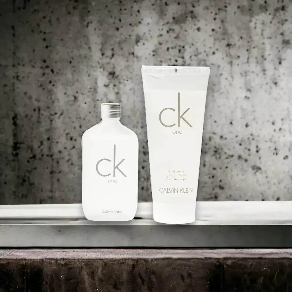 CK One Duftset mit Eau de Toilette und Body Wash vor grauem Hintergrund, Unisex-Parfum