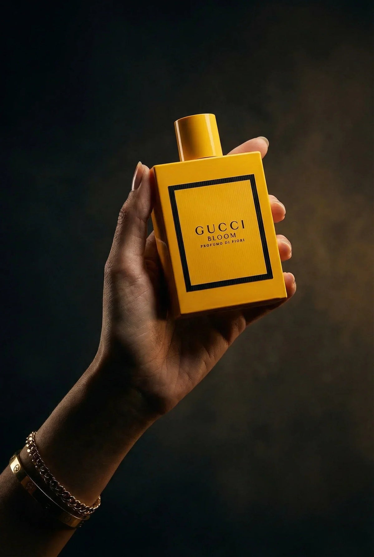 Eine Hand hält den gelben Flakon des Gucci Bloom Profumo di Fiori Parfums.