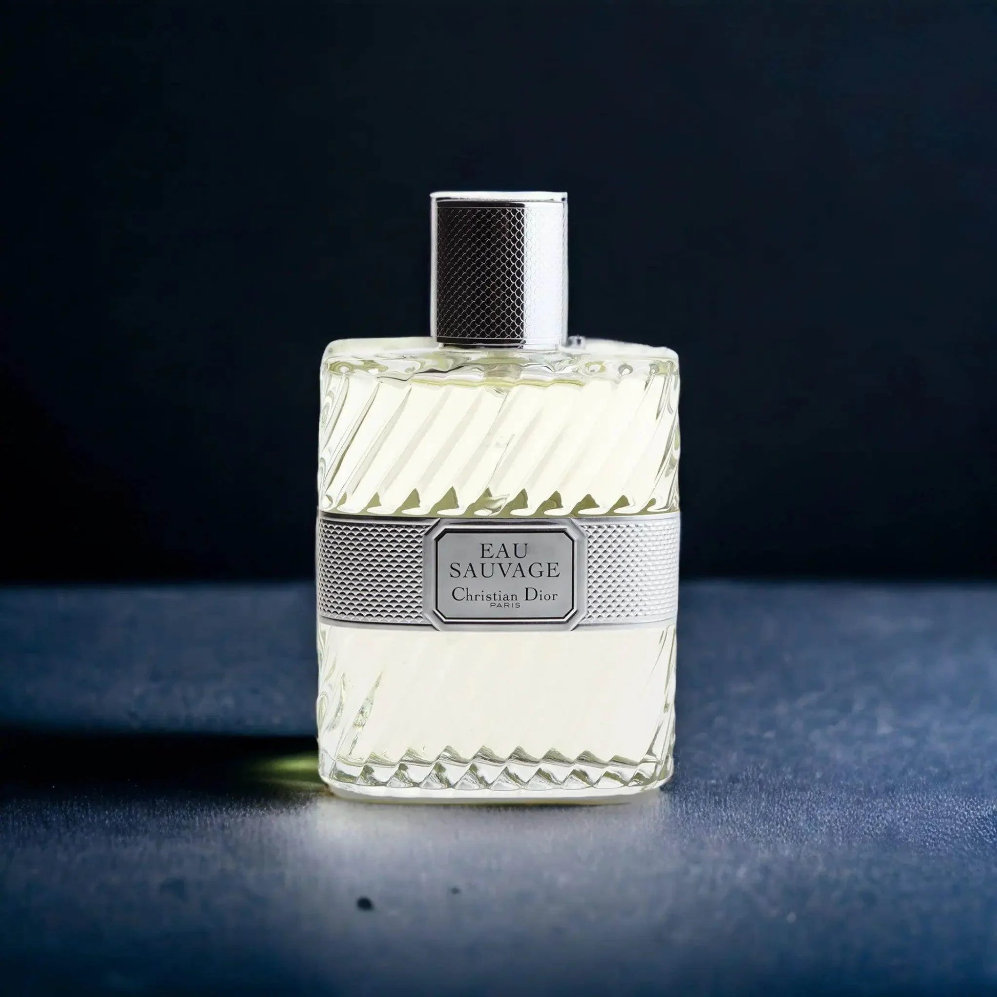 Luxuriöses Eau de Toilette Eau Sauvage Flakon mit silbernem Verschluss auf dunklem Hintergrund