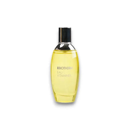 Gelbes Eau de Toilette Biotherm Eau Vitaminée Flakon mit silbernem Deckel auf weißem Hintergrund