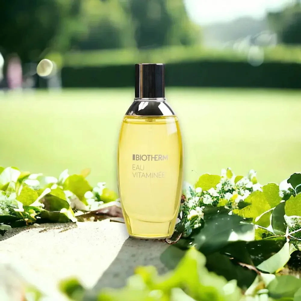 Biotherm Eau Vitaminée Eau de Toilette Flakon auf Stein mit grünen Blättern im Sonnenlicht