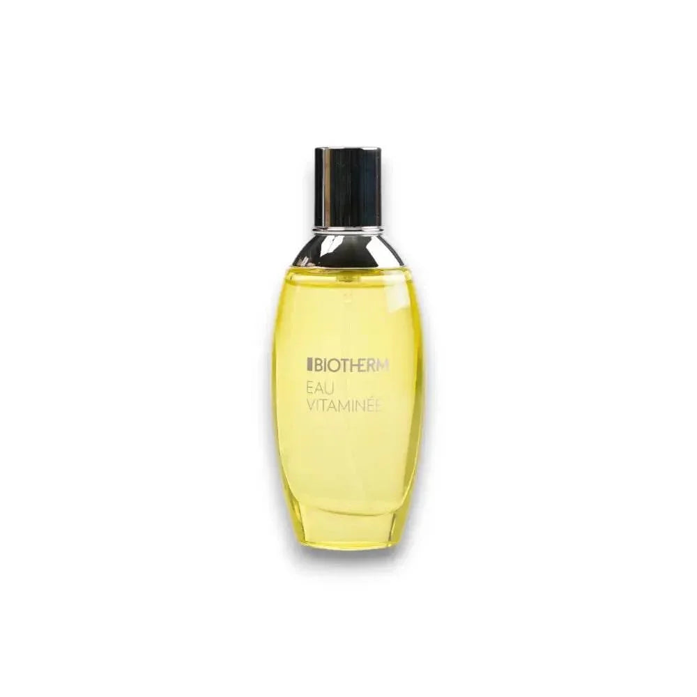 Gelbes Eau de Toilette Biotherm Eau Vitaminée Flakon mit silbernem Verschluss auf weißem Hintergrund.