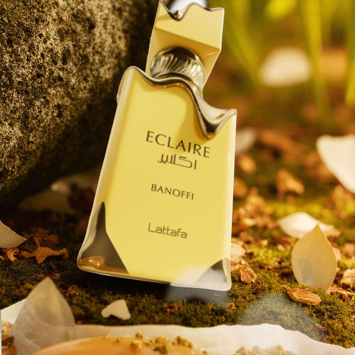 Eclaire Banoffi Parfümflakon 100ml auf moosigem Untergrund mit goldener Verpackung