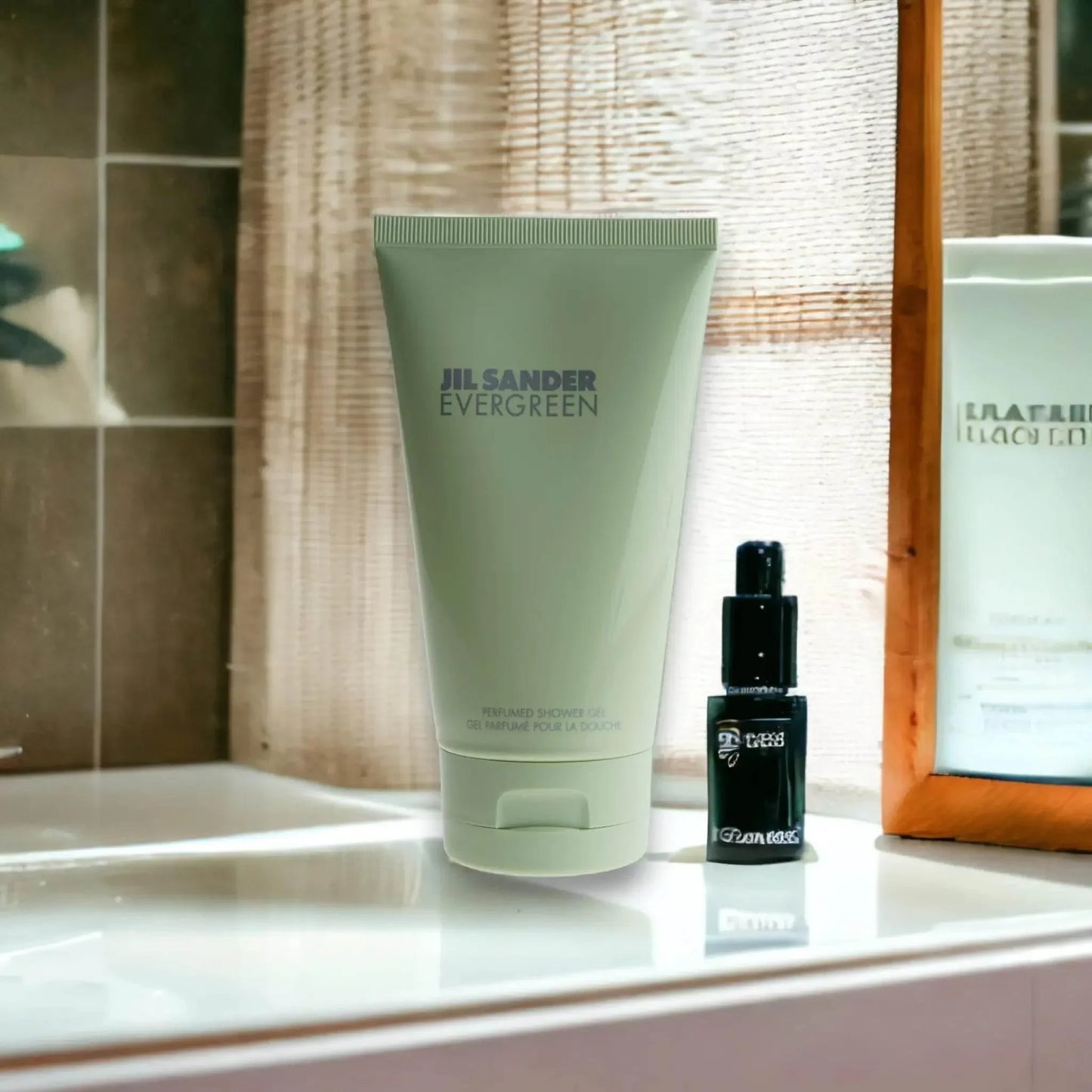 Jil Sander Evergreen Duschgel im Bad auf dem Waschbecken, neben kleinem Flacon