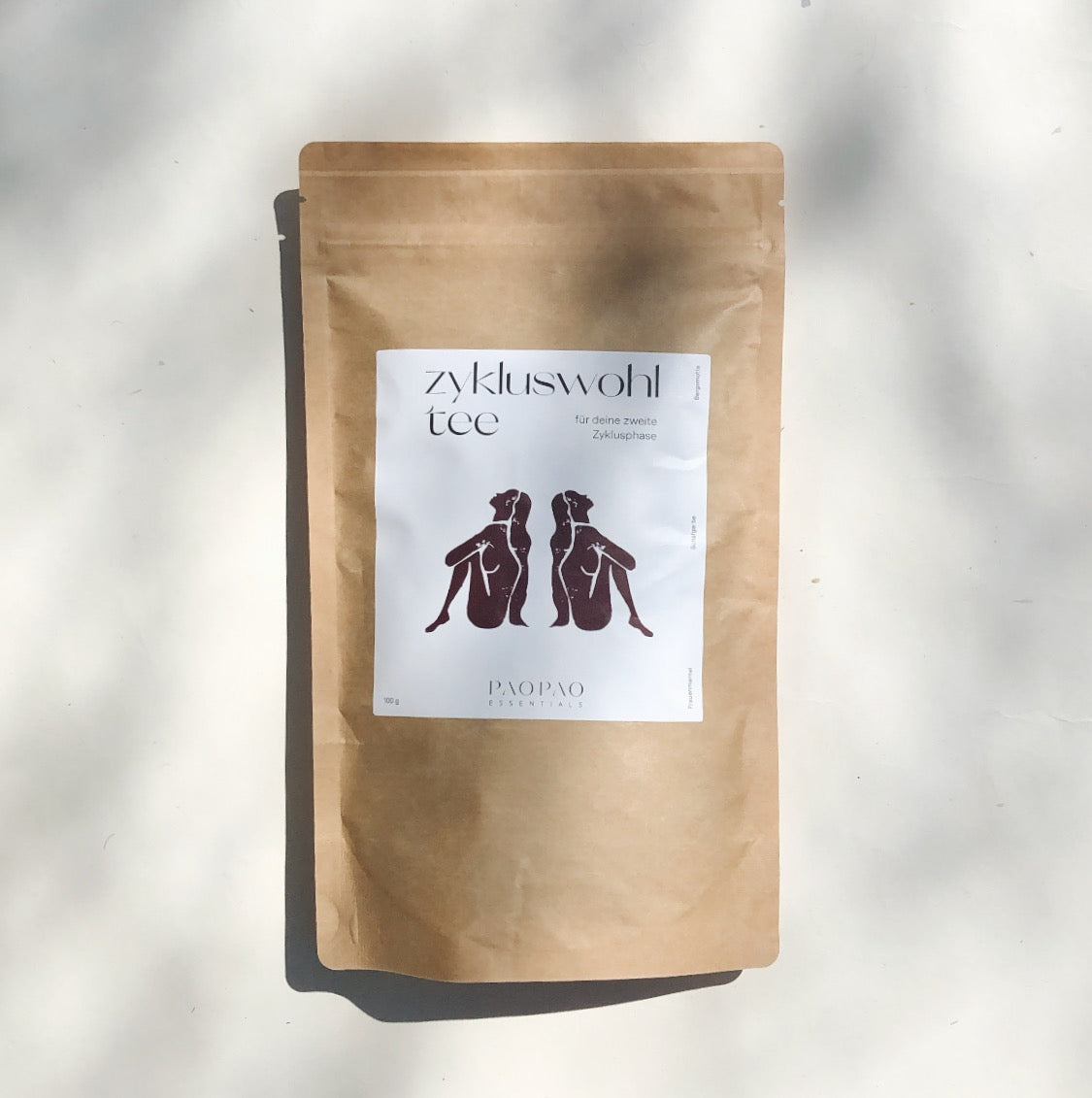 Braune Teepackung von paopao essentials Zykluswohl Tee auf weißem Hintergrund.