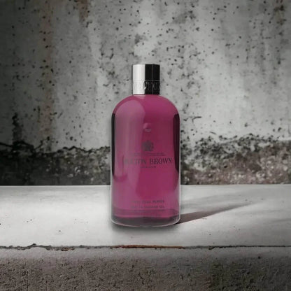 Pinkfarbenes Duschgel in transparenter Flasche vor grauem Hintergrund, luxuriöse Pflege
