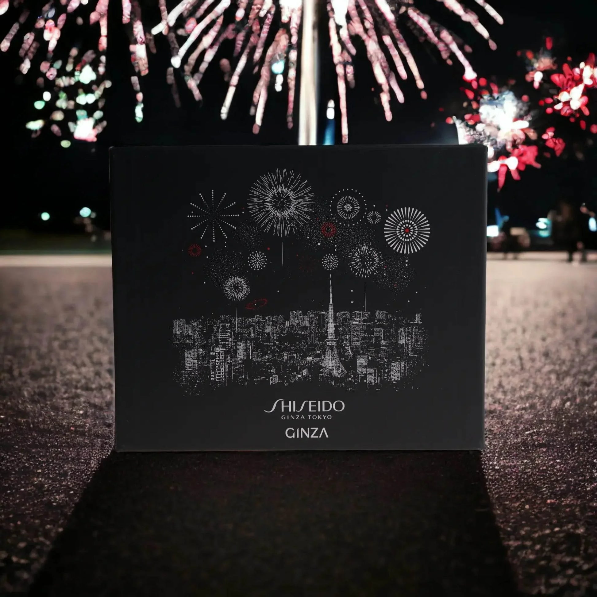 Shiseido Ginza Duftset vor Feuerwerk, elegante schwarze Verpackung mit Stadt- und Feuerwerksmotiv