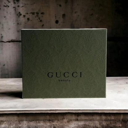 Elegantes grünes Gucci Geschenkset für Herrenparfum vor rustikalem Hintergrund.