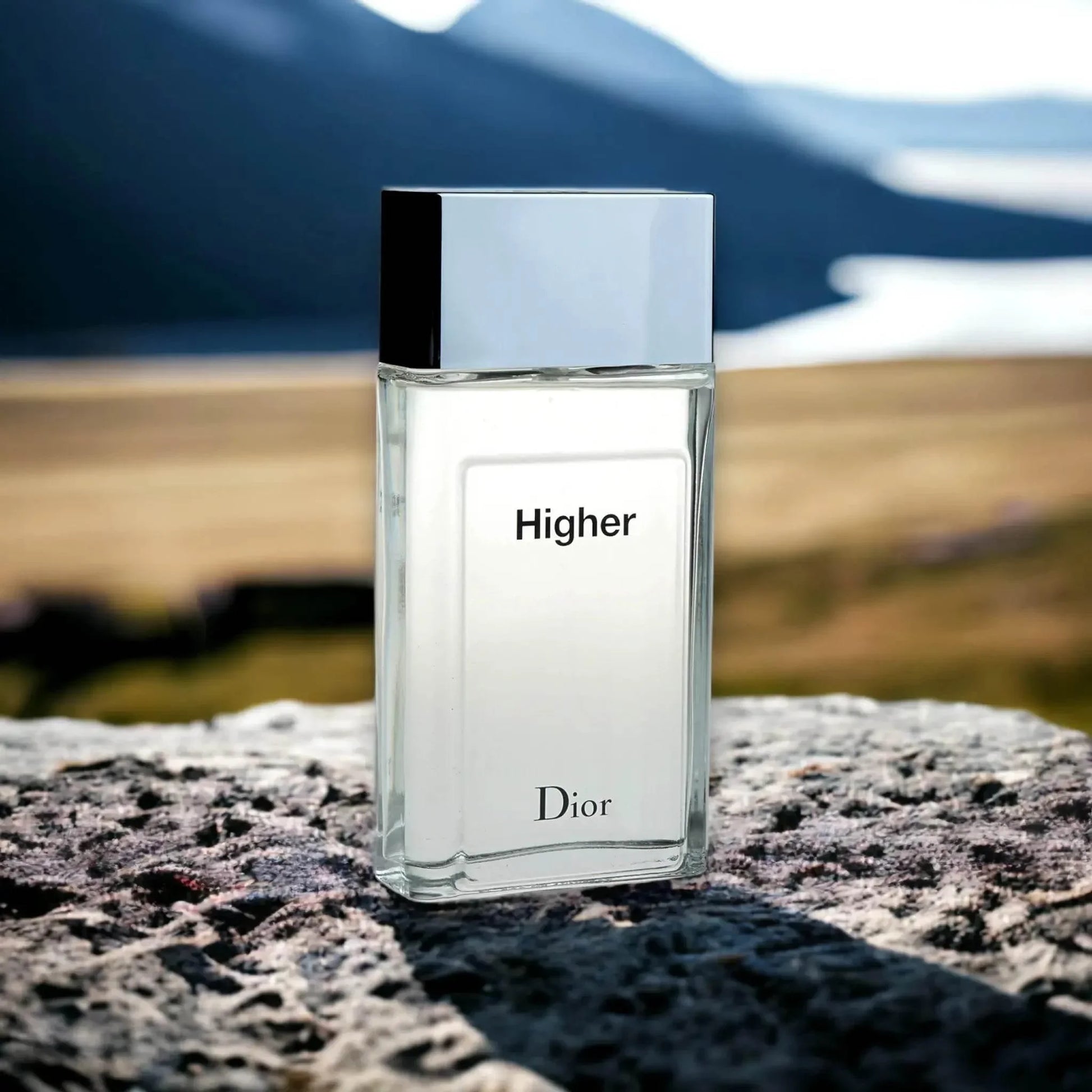 Edler Herrenduft Higher Eau de Toilette Flakon auf Naturstein vor Berglandschaft