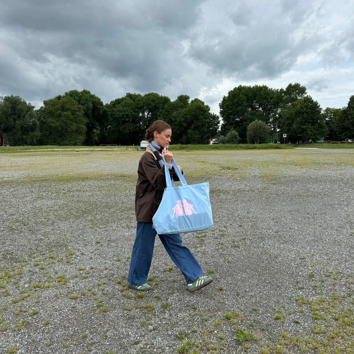 Frau mit paopao essentials Tote Bag 'sacred feminine' auf einer grauen Kiesfläche.