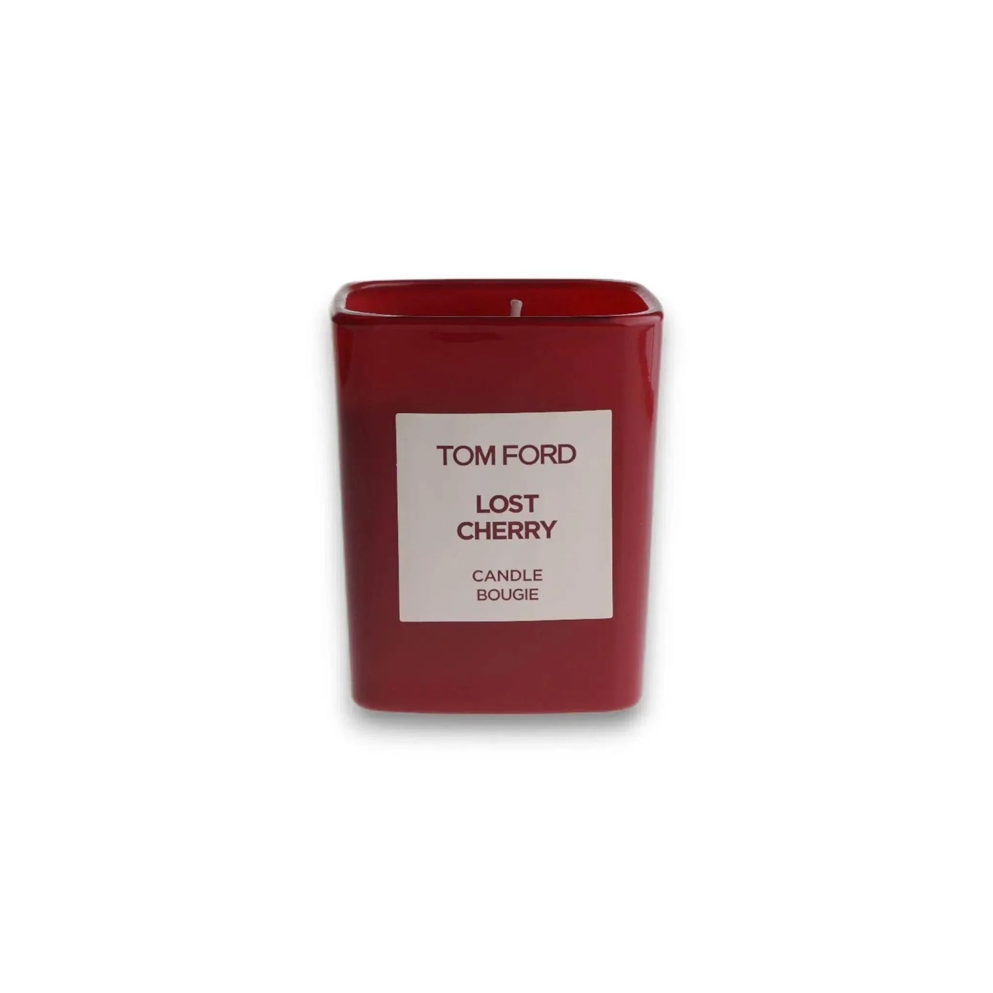 Rote Duftkerze in rechteckigem Glas mit Aufschrift 'TOM FORD Lost Cherry', isoliert auf Weiß.