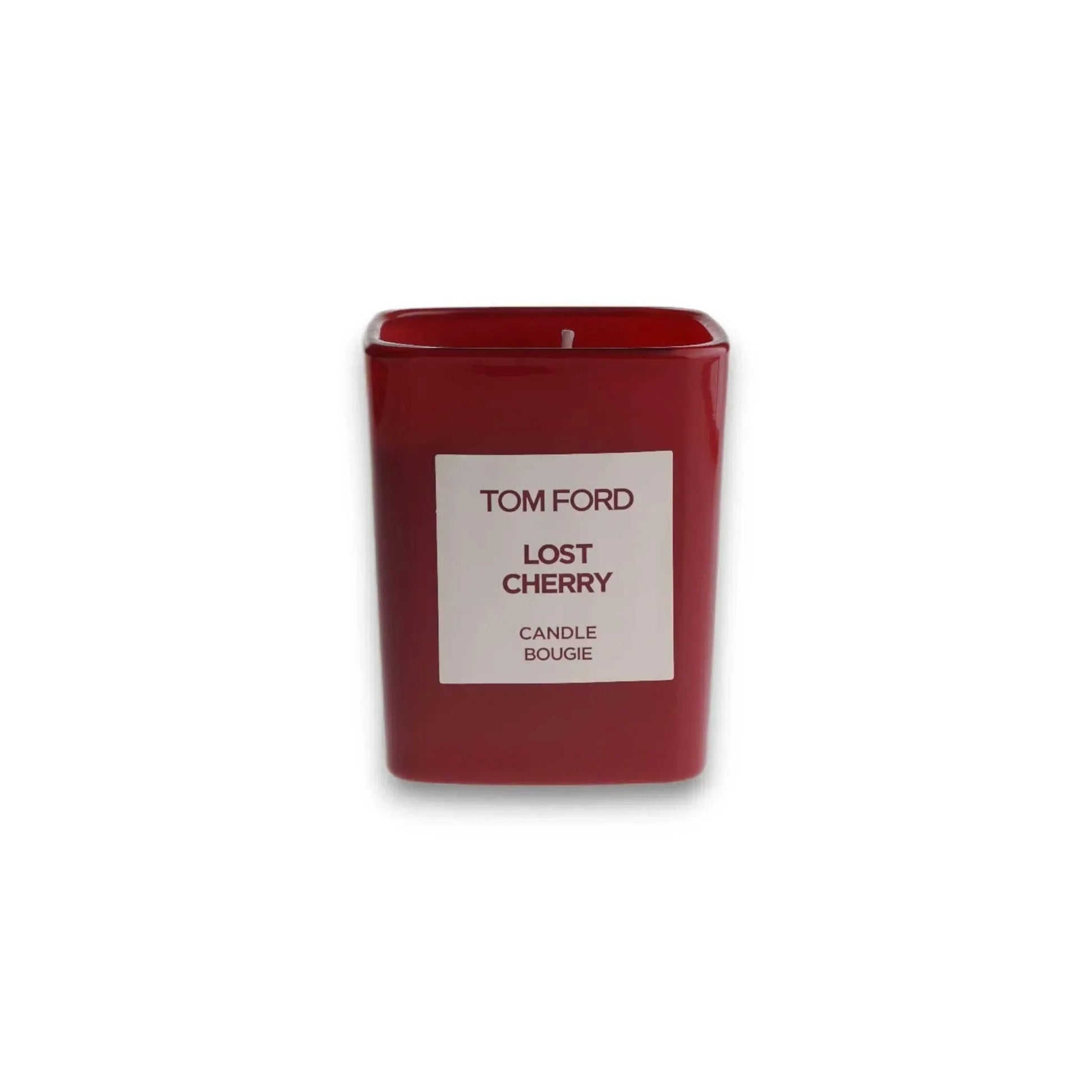Rote Duftkerze in rechteckigem Glas mit Aufschrift 'TOM FORD Lost Cherry', isoliert auf Weiß.