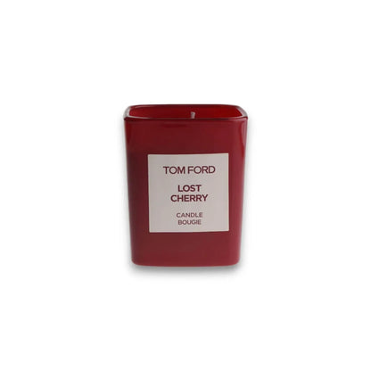 Rote Duftkerze in rechteckigem Glas mit Aufschrift 'TOM FORD Lost Cherry', isoliert auf Weiß.