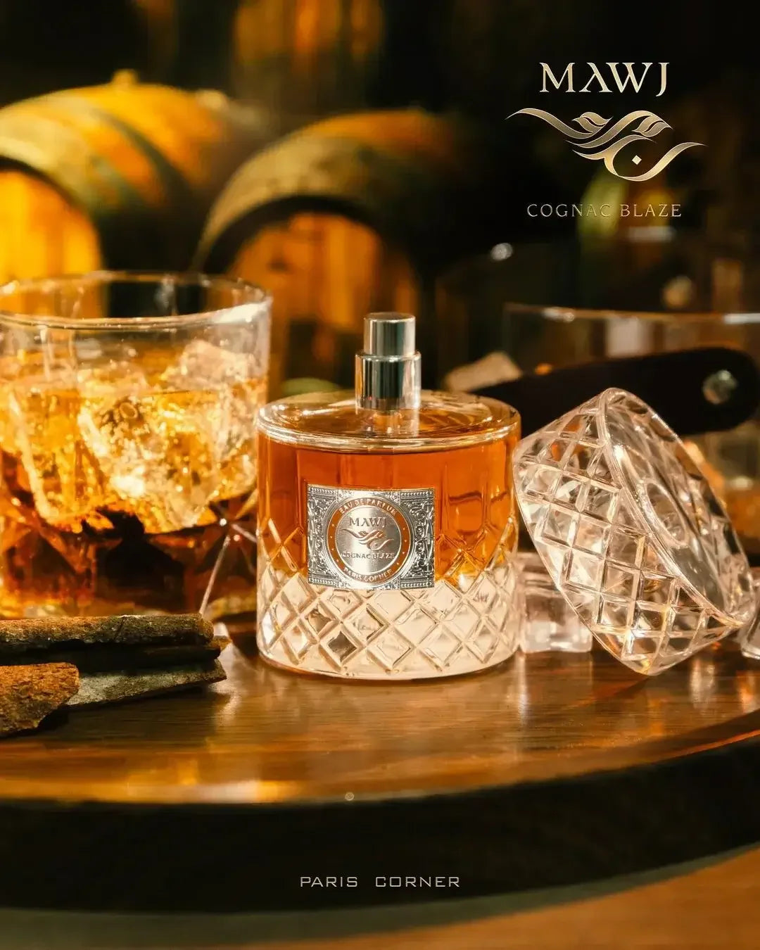 Luxusparfum MAWJ Cognac Blaze mit elegantem Glasflakon und Whiskeyglas auf Holz, Barrels im Hintergrund