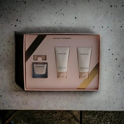 Narciso Poudrée Duftset mit Eau de Parfum, Body Lotion und Duschgel auf Marmoroberfläche.