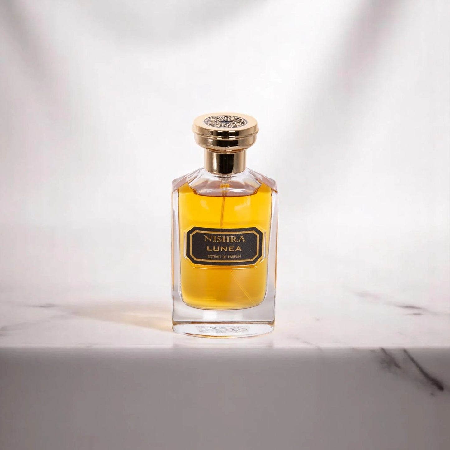 Luxus Parfum Flakon Nishra Lunea mit goldener Kappe auf hellem Hintergrund