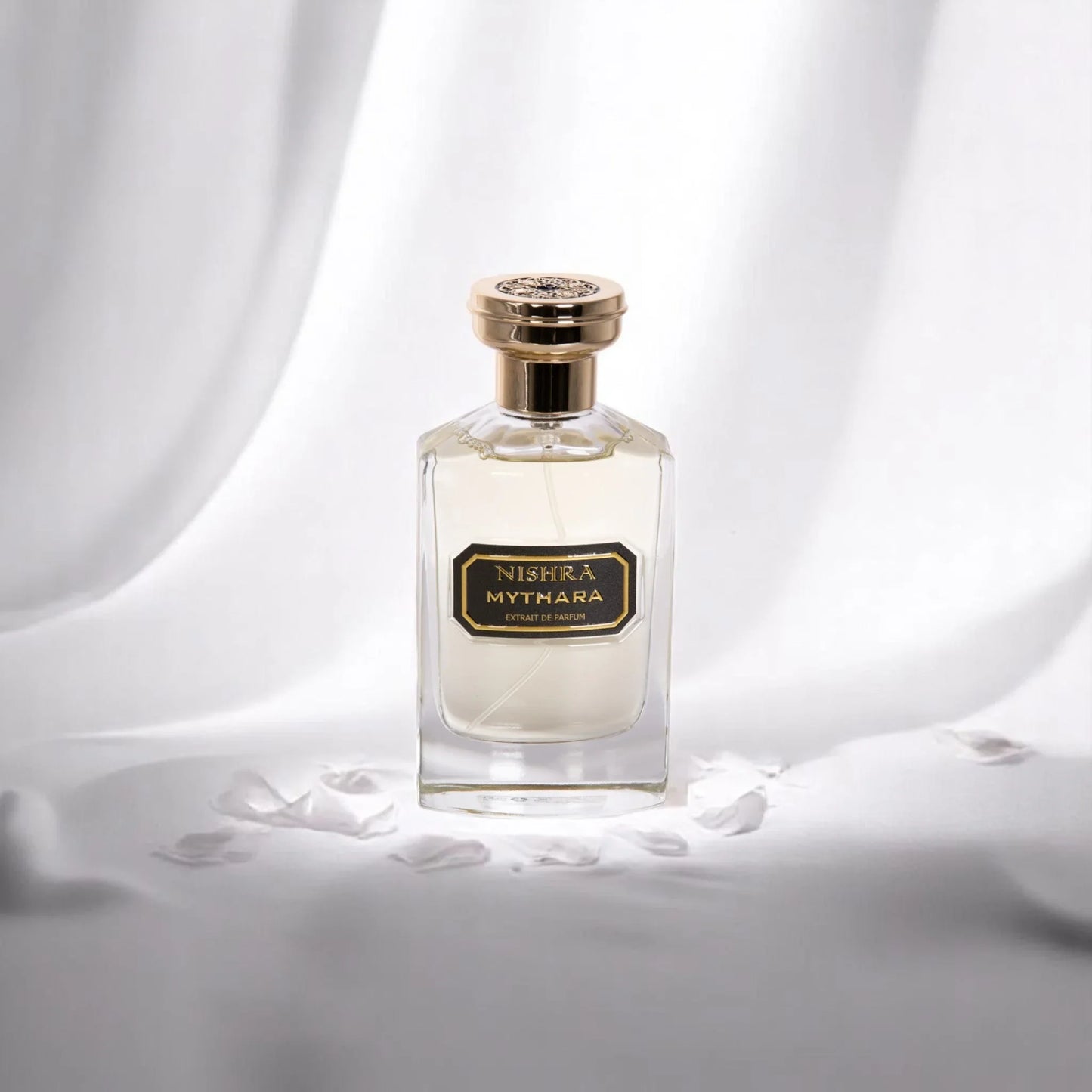 Luxus Parfumflakon Nishra Mythara auf weißem Stoff mit goldfarbenem Verschluss