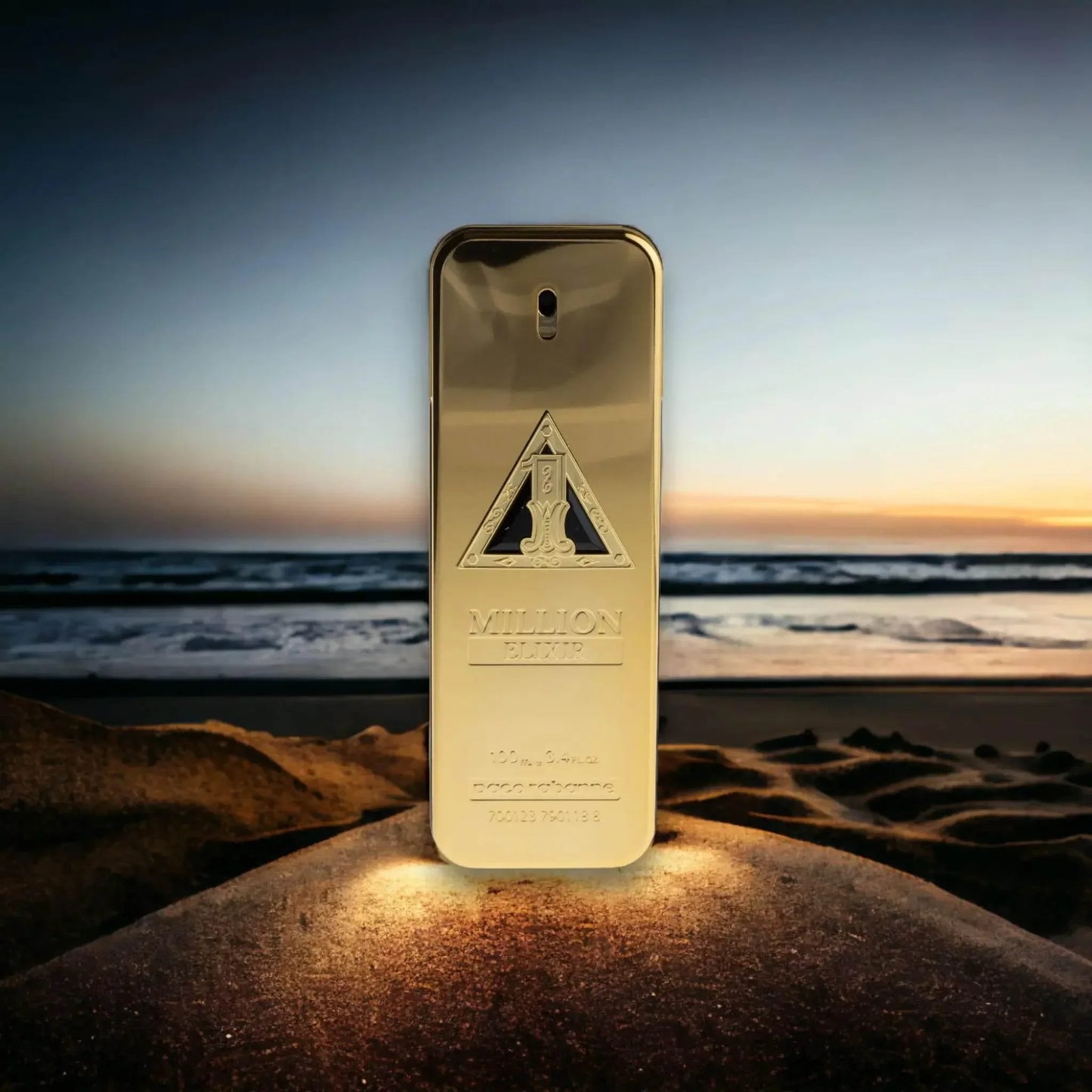 Goldener Parfumflakon One Million Elixir auf Sand vor Sonnenuntergang am Meer