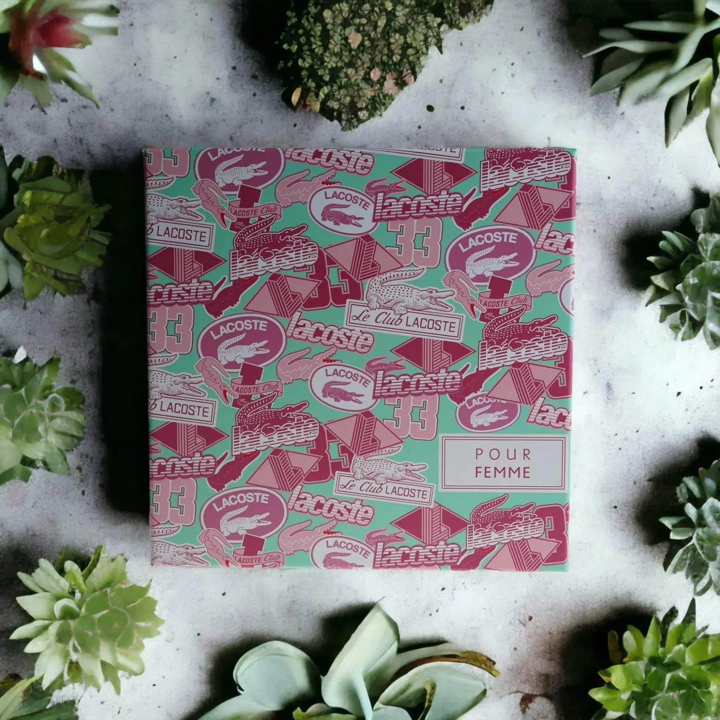 Feminines Parfümset in bunter Geschenkbox, umgeben von Sukkulenten, Frühlingsdesign