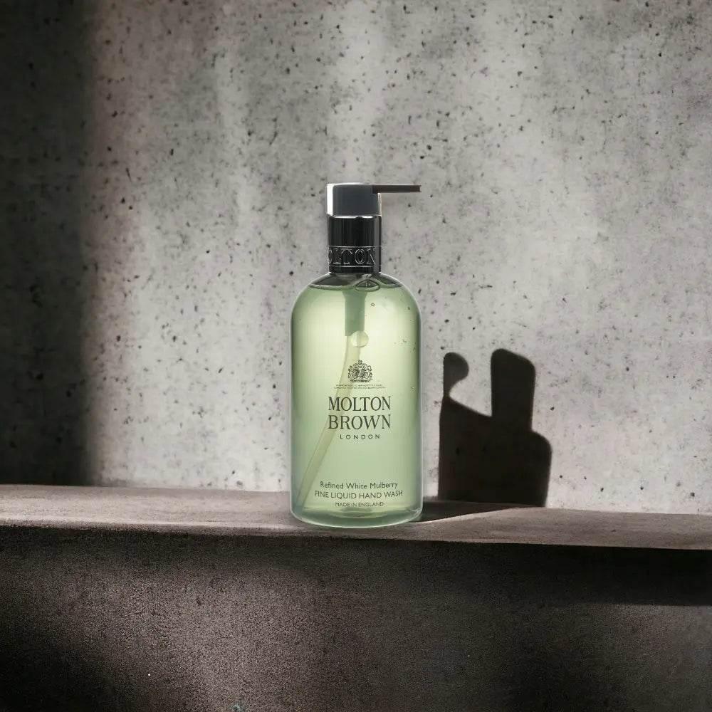 Molton Brown Refined White Mulberry Flüssigseife in eleganter Pumpflasche auf Betonoberfläche