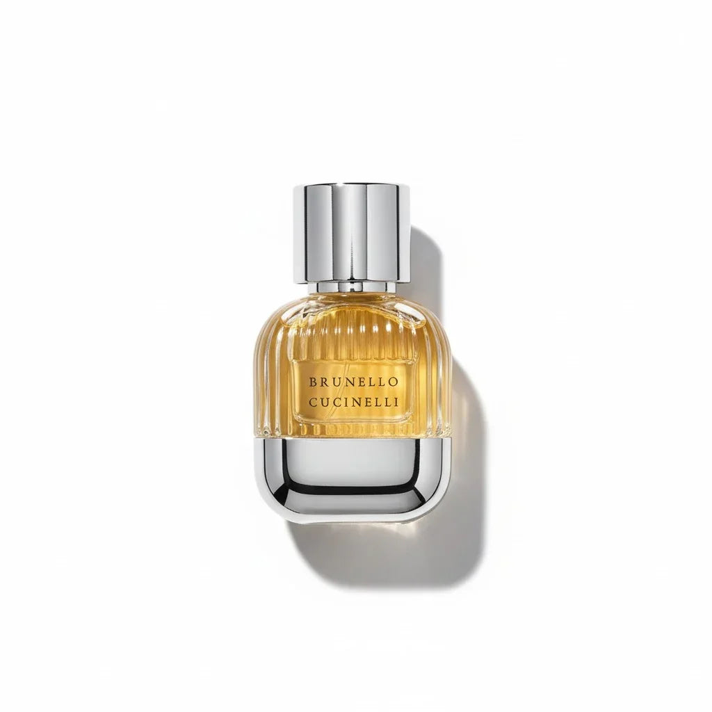 Ein Flakon Brunello Cucinelli pour Homme Eau de Parfum mit goldenem Inhalt und Silberdeckel.
