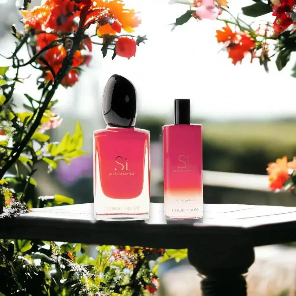 Si Passione Eau de Parfum Duftset in roten Flakons auf Holztisch, umgeben von Blumen