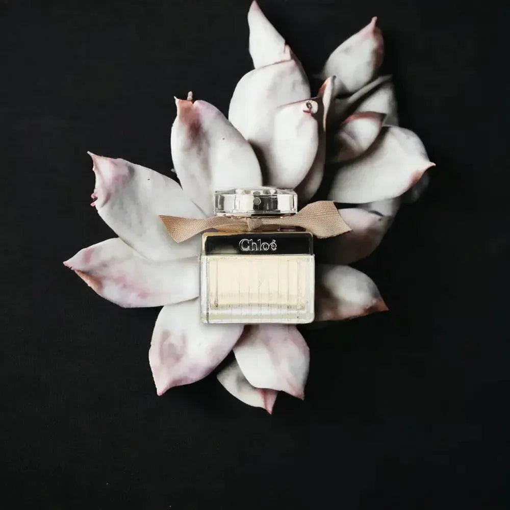 Elegantes Damenparfum-Flakon vor heller Blüte auf dunklem Hintergrund, luxuriöses Duftprodukt.