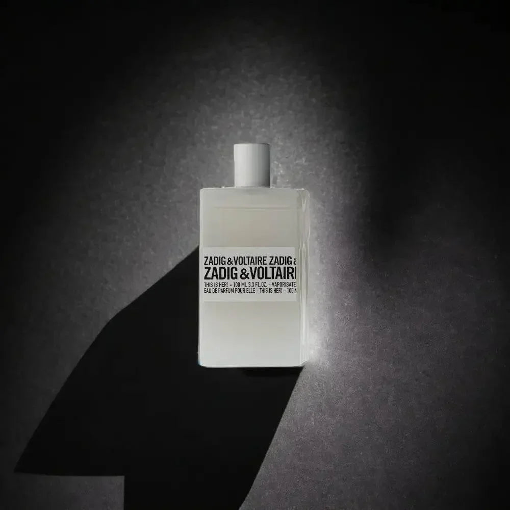 Weißer Parfumflakon Zadig & Voltaire This is Her spielt auf dunklem Hintergrund