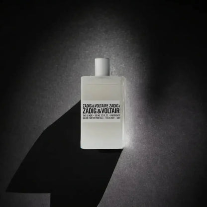 Weißer Parfumflakon Zadig & Voltaire This is Her spielt auf dunklem Hintergrund