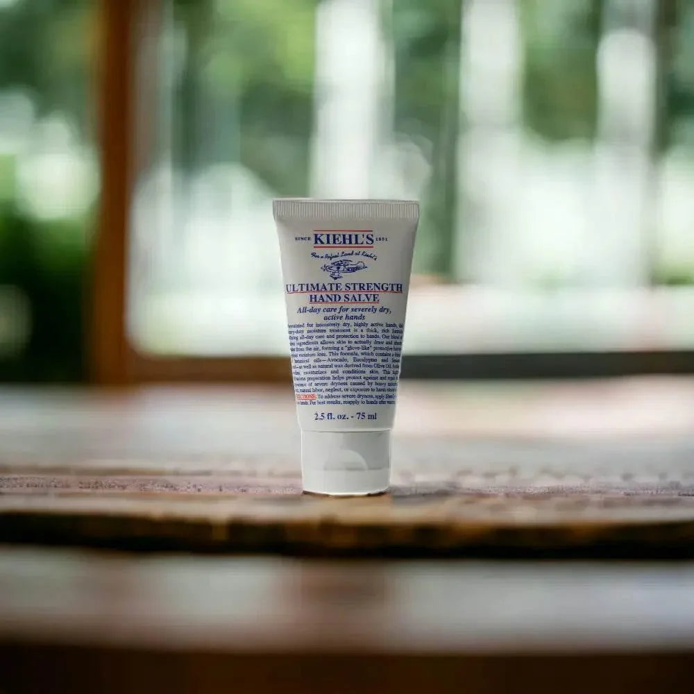 Handcreme Tube für trockene, rissige Hände auf Holztisch vor unscharfem Hintergrund