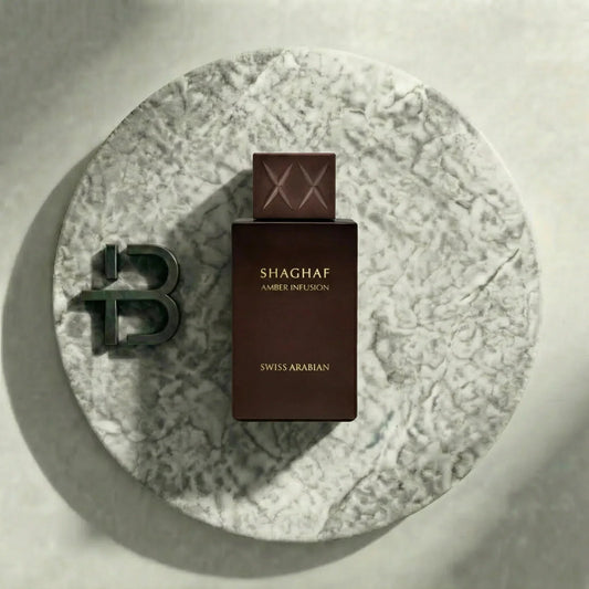 Braunes Parfumflakon Shaghaf Amber Infusion von Swiss Arabian auf rundem Marmortablett