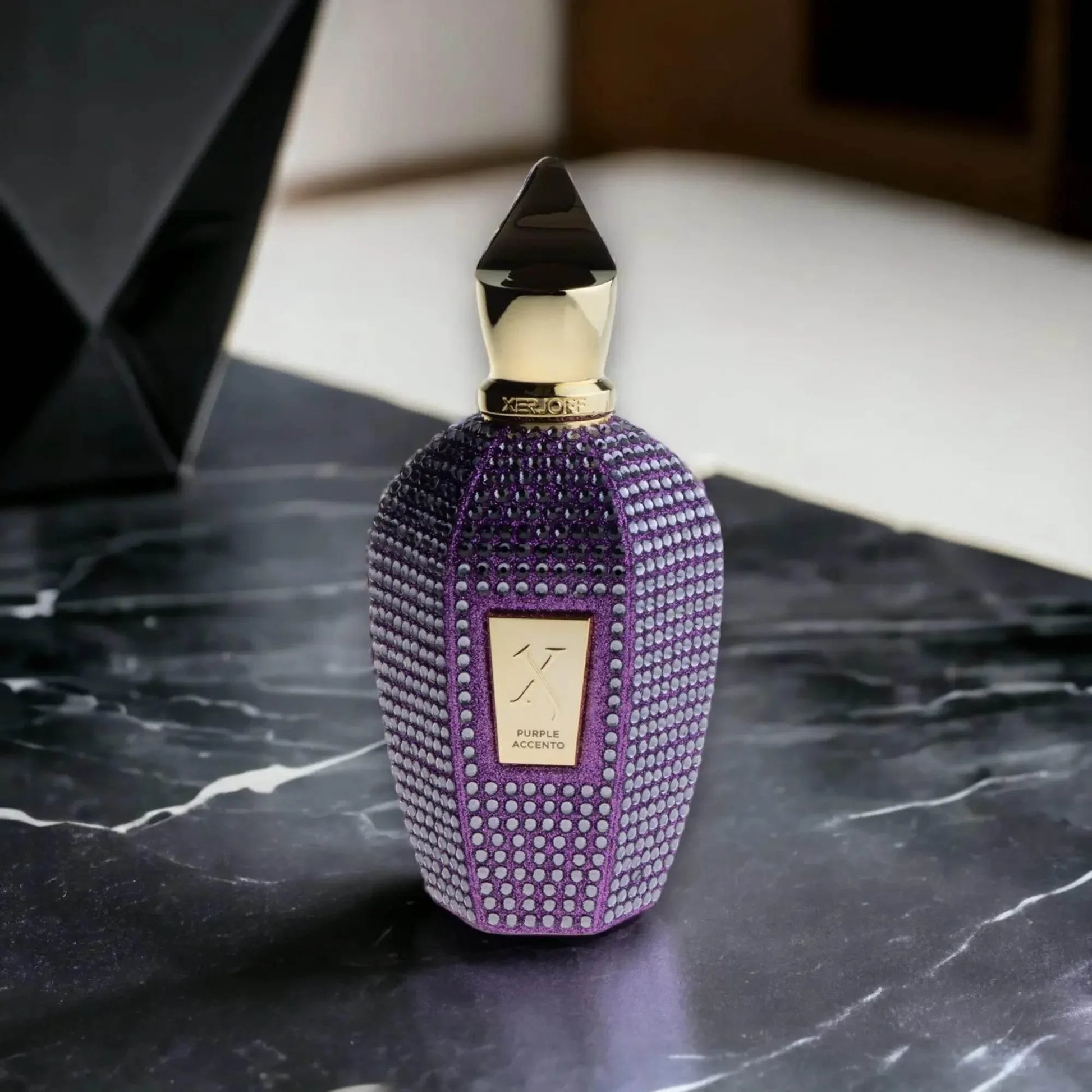Luxuriöses lila Parfumflakon mit Goldakzent auf Marmortisch, exklusives Damenparfum