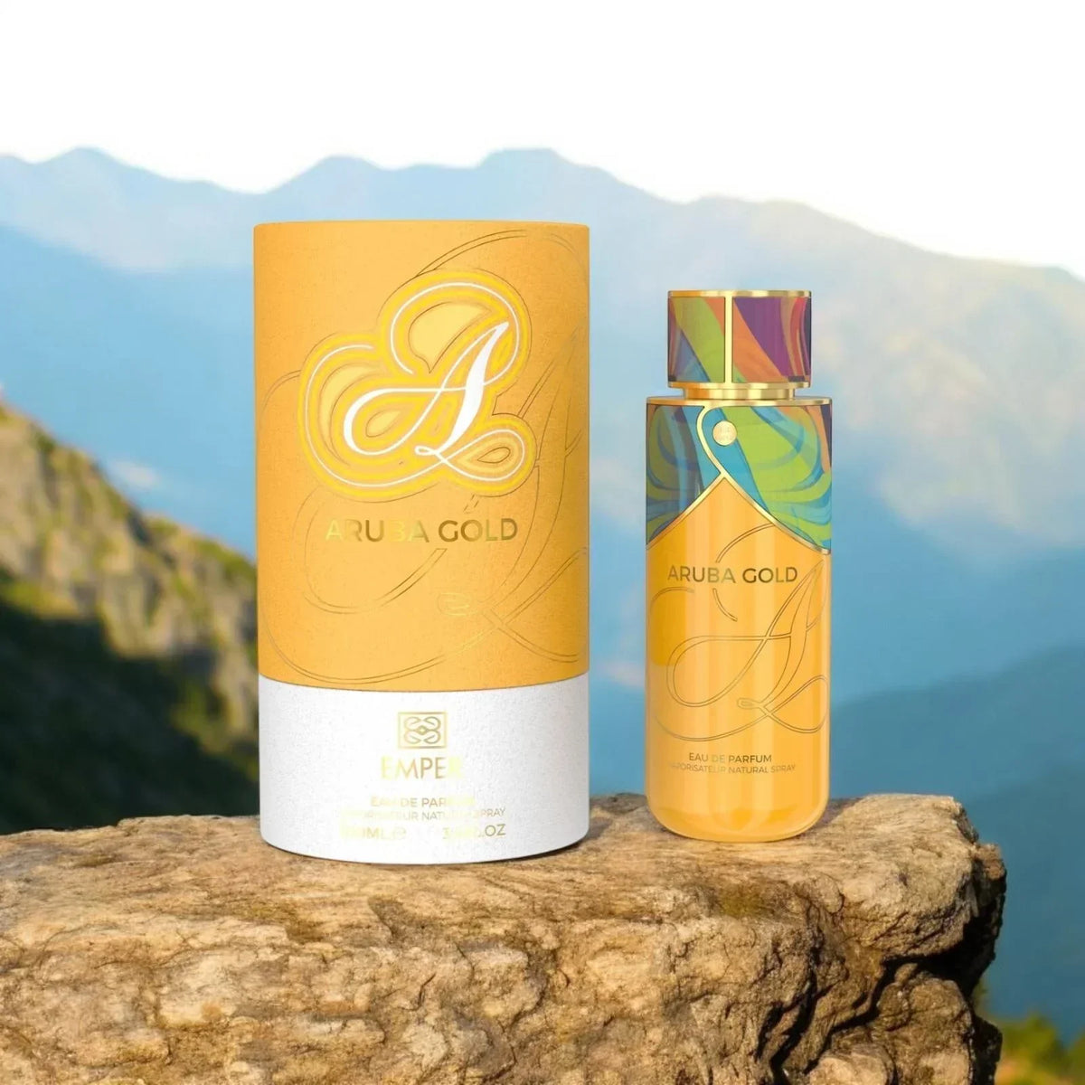 Emper Aruba Gold Eau de Parfum Flakon und Verpackung vor einer Berglandschaft.