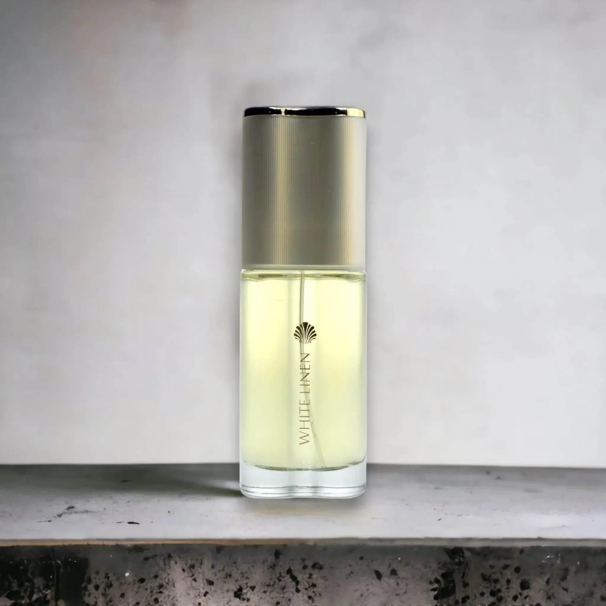 Edles Damenparfum White Linen im eleganten Glasflakon mit silbernem Deckel auf grauem Untergrund