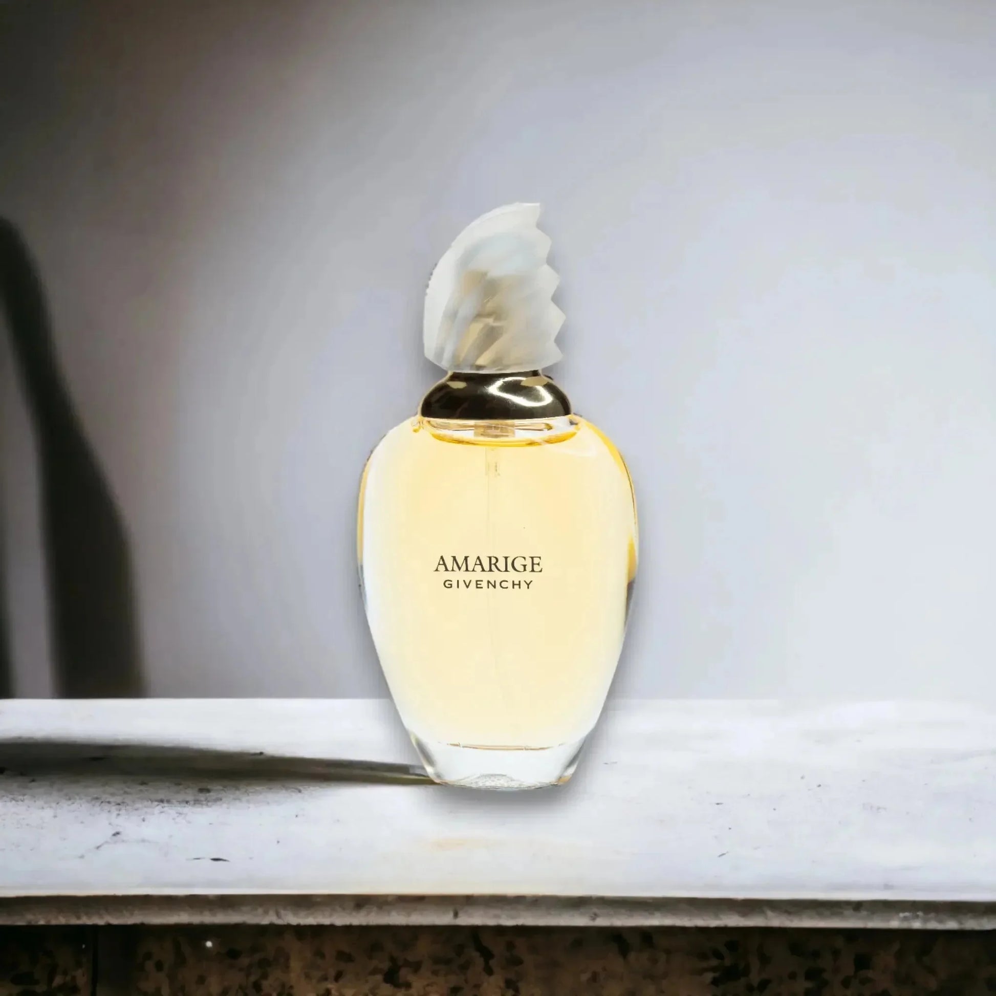 Eleganter Damenparfum-Flakon mit goldgelbem Amarige Eau de Toilette auf Steinplatte