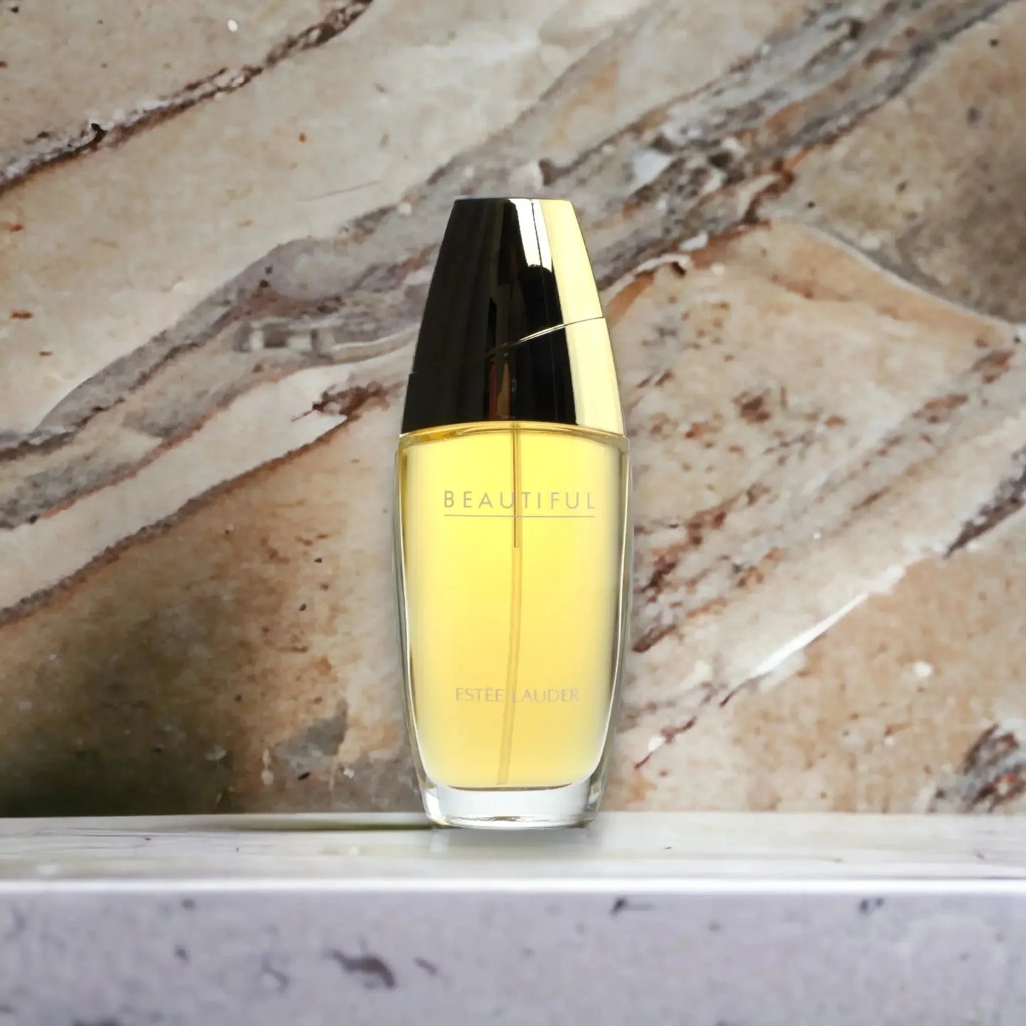 Eleganter Damenparfum-Flakon mit goldener Kappe vor Marmorhintergrund, Eau de Parfum